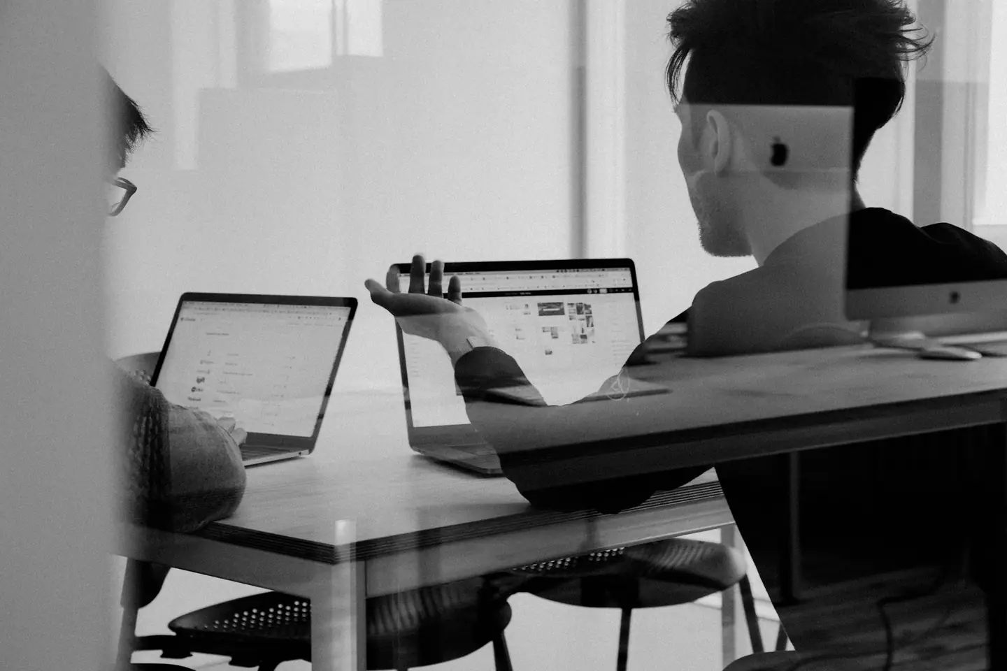 Black and white photo of a person working at a laptop