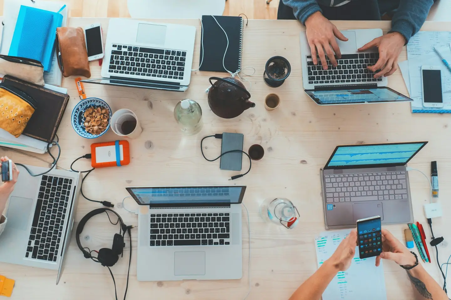 Overhead view of a team working on laptops around a table