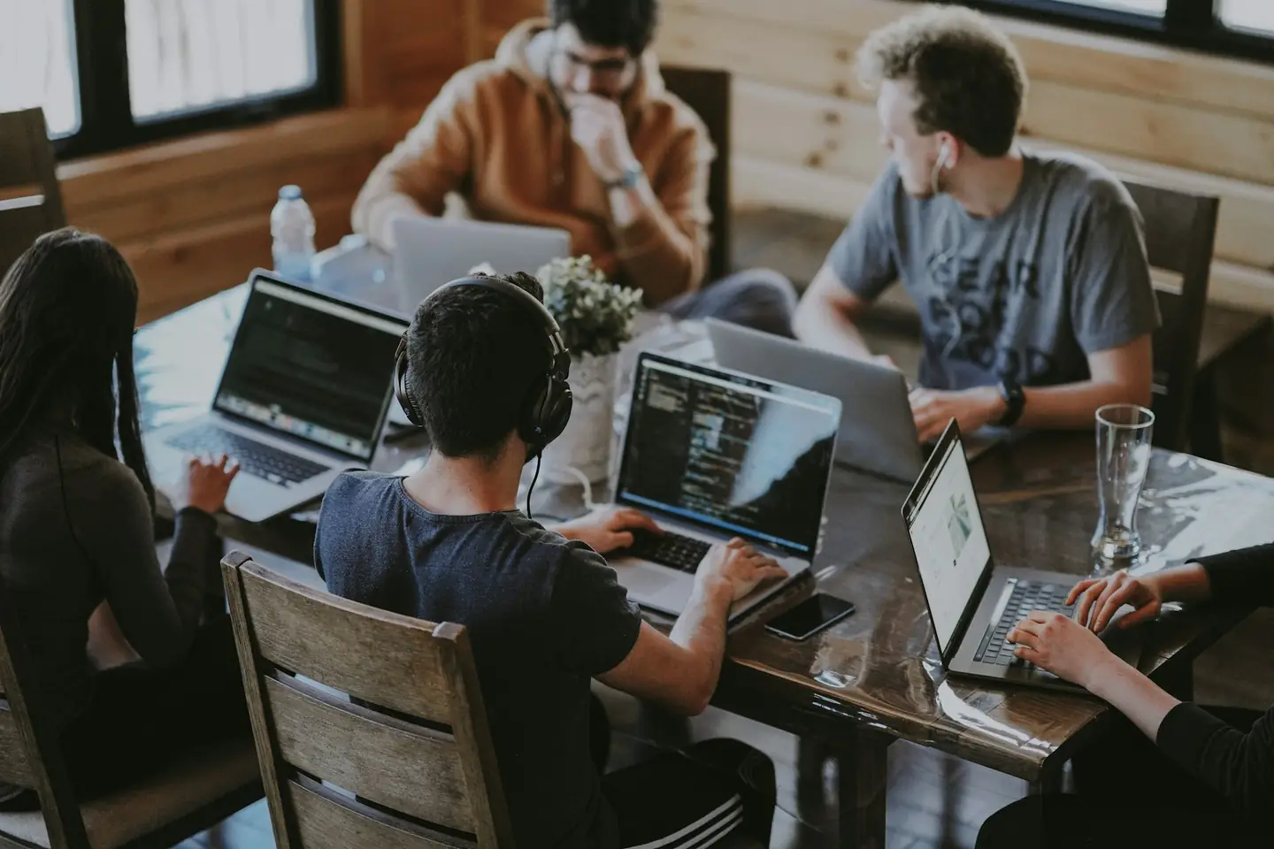 Marketing team working on laptops together at a shared table